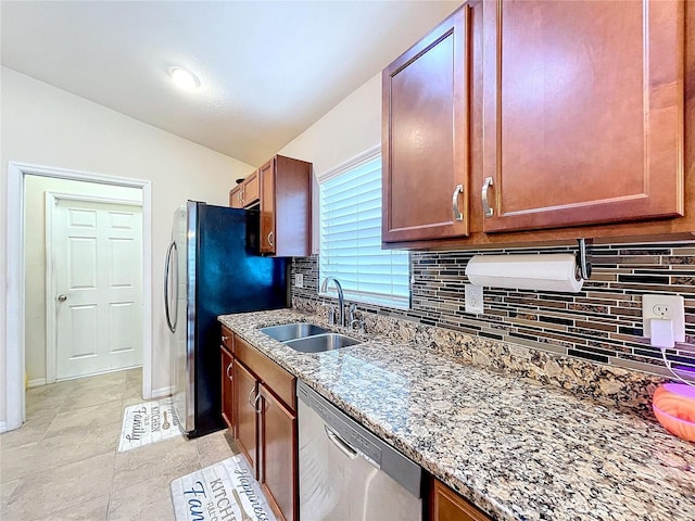 kitchen featuring stone counters, sink, tasteful backsplash, light tile patterned floors, and appliances with stainless steel finishes