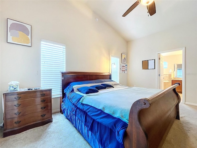 bedroom featuring multiple windows, connected bathroom, light colored carpet, and ceiling fan