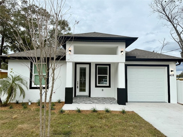 view of front of house featuring a porch, a garage, and a front lawn