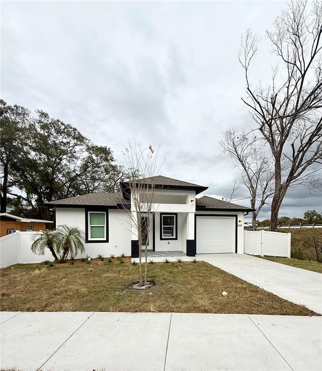 prairie-style home featuring a front yard and a garage