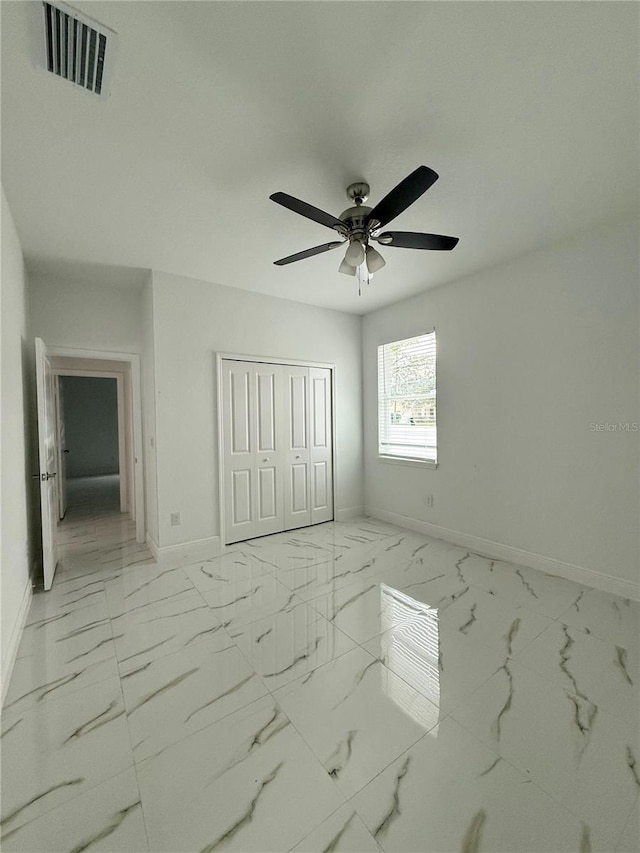 unfurnished bedroom featuring ceiling fan and a closet