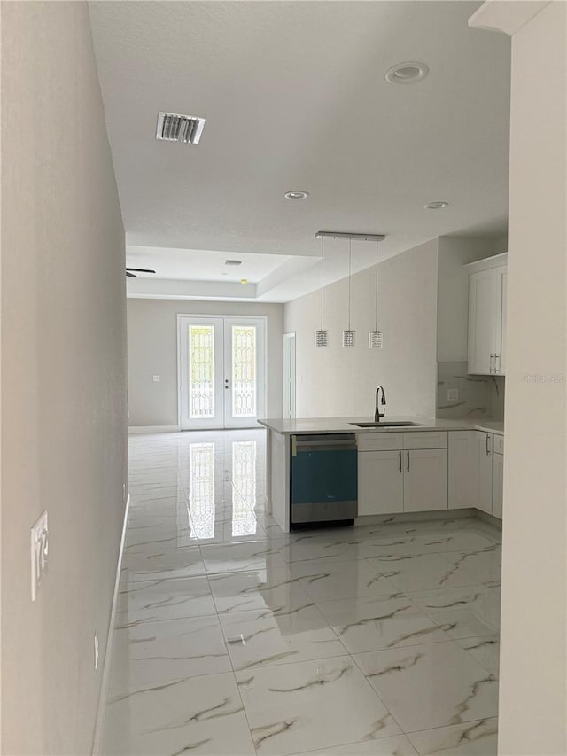 kitchen with french doors, stainless steel dishwasher, sink, white cabinetry, and hanging light fixtures