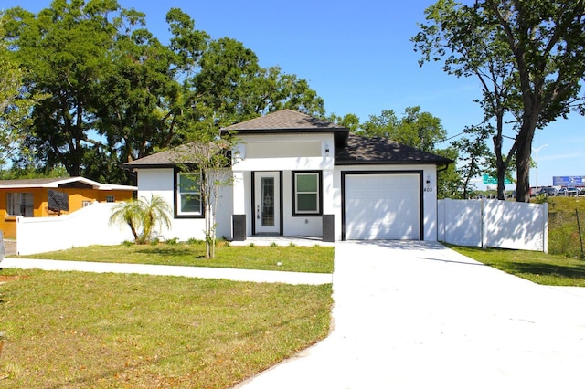 408 E Hanlon St, Tampa, FL 33604 - view of front facade featuring stucco siding, a garage, fence, and a front lawn
