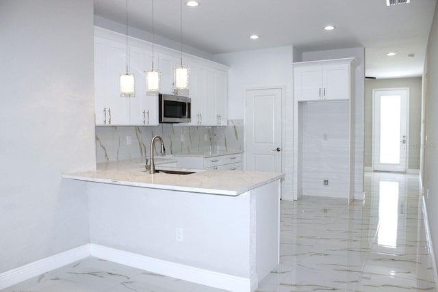 408 E Hanlon St, Tampa, FL 33604 - kitchen with stainless steel microwave, light stone countertops, marble finish floor, a sink, and a peninsula