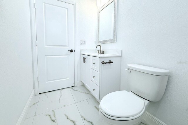 408 E Hanlon St, Tampa, FL 33604 - bathroom with baseboards, marble finish floor, toilet, and vanity