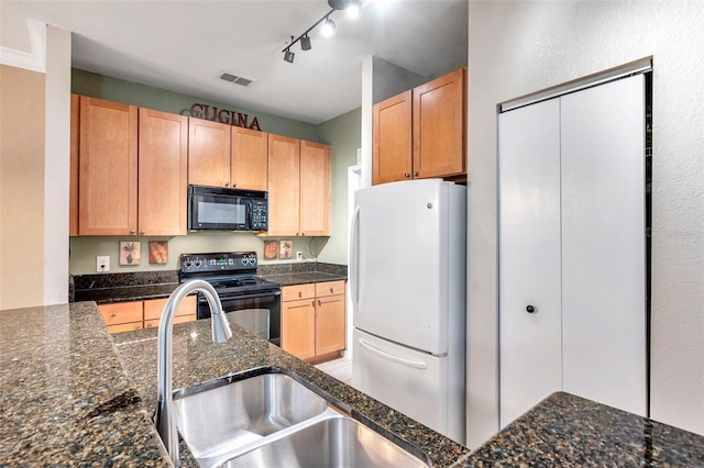 kitchen with dark stone countertops, sink, black appliances, and track lighting