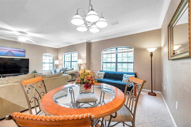 carpeted dining area with ceiling fan with notable chandelier, plenty of natural light, and crown molding