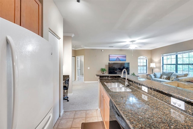 kitchen with dark stone counters, sink, black dishwasher, white fridge, and light colored carpet