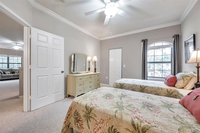 bedroom with a closet, light colored carpet, ceiling fan, and crown molding