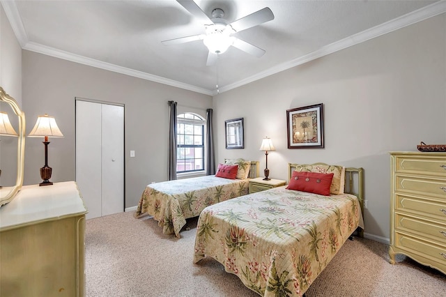 carpeted bedroom with a closet, ceiling fan, and ornamental molding