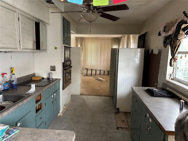 kitchen featuring tile patterned floors, ceiling fan, black appliances, and sink