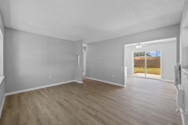 spare room featuring ceiling fan, a textured ceiling, and light wood-type flooring