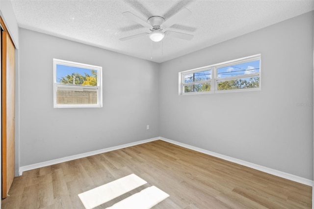 empty room featuring ceiling fan, a textured ceiling, and light hardwood / wood-style flooring