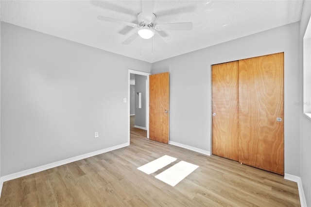 unfurnished bedroom featuring a textured ceiling, light wood-type flooring, a closet, and ceiling fan