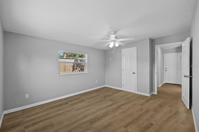 unfurnished bedroom featuring ceiling fan, wood-type flooring, and a closet