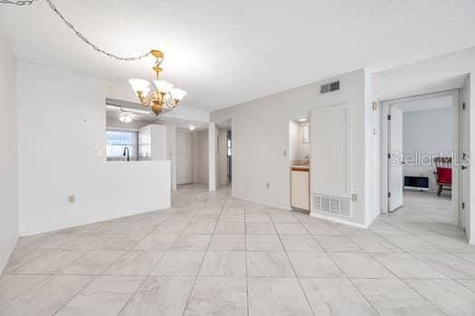 unfurnished room featuring a chandelier