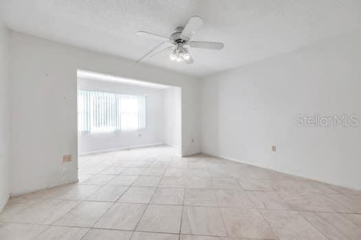 spare room featuring light tile patterned flooring and ceiling fan