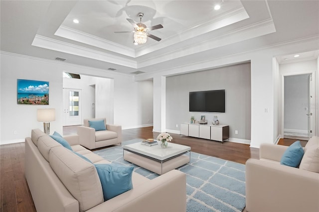 living room featuring a raised ceiling, ceiling fan, hardwood / wood-style floors, and crown molding