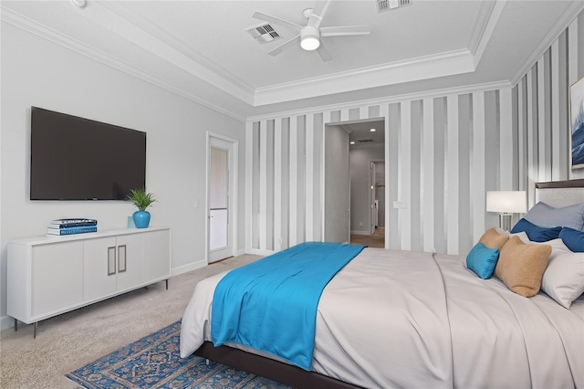 carpeted bedroom featuring a tray ceiling, ceiling fan, and crown molding