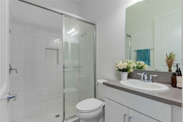 bathroom featuring an enclosed shower, vanity, and toilet