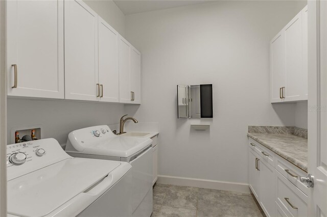 laundry area with washer and dryer, cabinets, and sink