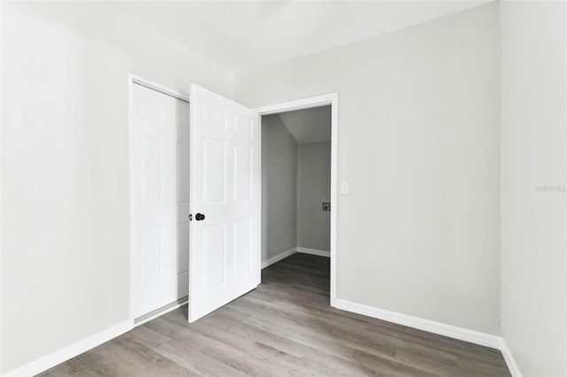 unfurnished bedroom with hardwood / wood-style flooring and a closet