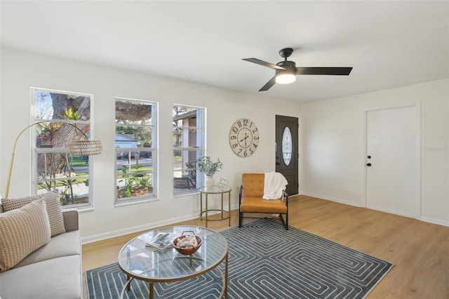 sitting room with ceiling fan and wood-type flooring