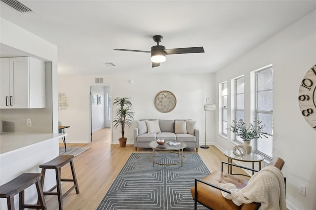 living room with ceiling fan and light hardwood / wood-style flooring