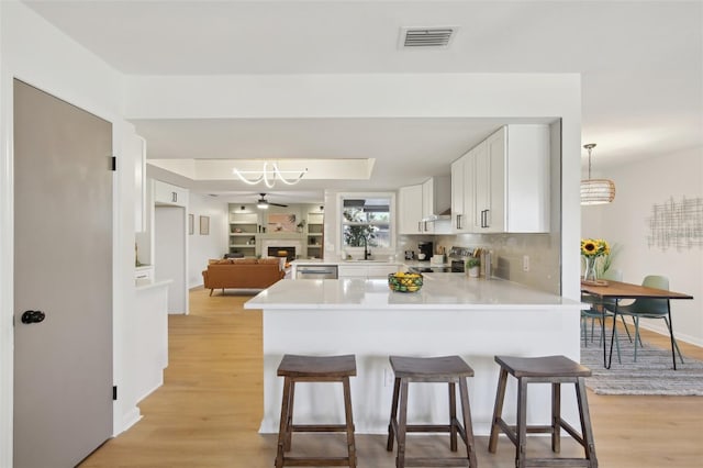 kitchen with kitchen peninsula, white cabinetry, pendant lighting, and appliances with stainless steel finishes