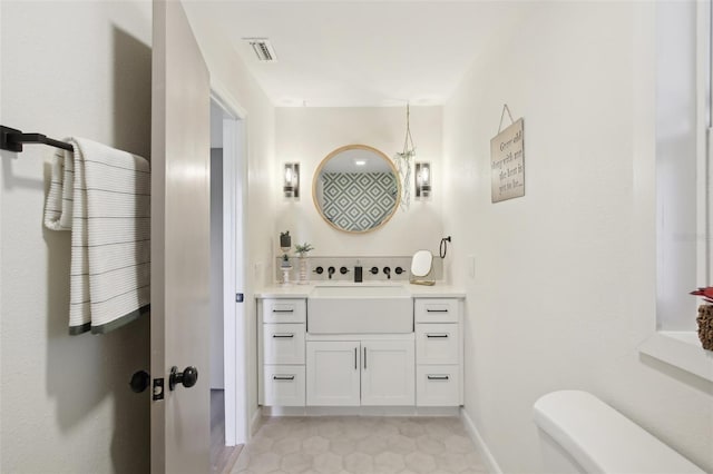 bathroom with toilet, vanity, and tile patterned floors