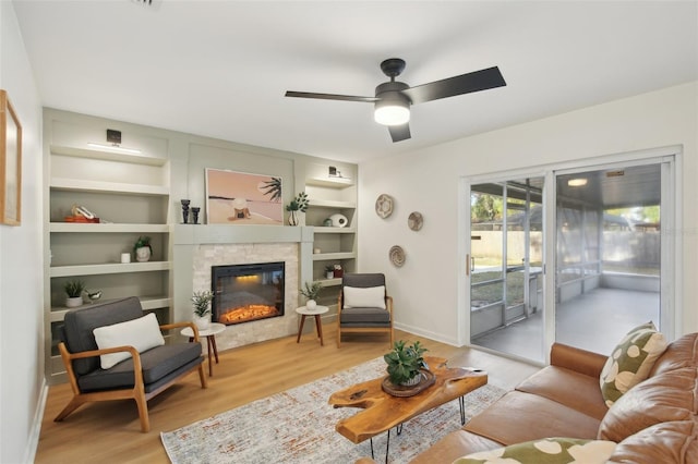 living room featuring ceiling fan, light hardwood / wood-style floors, and built in features