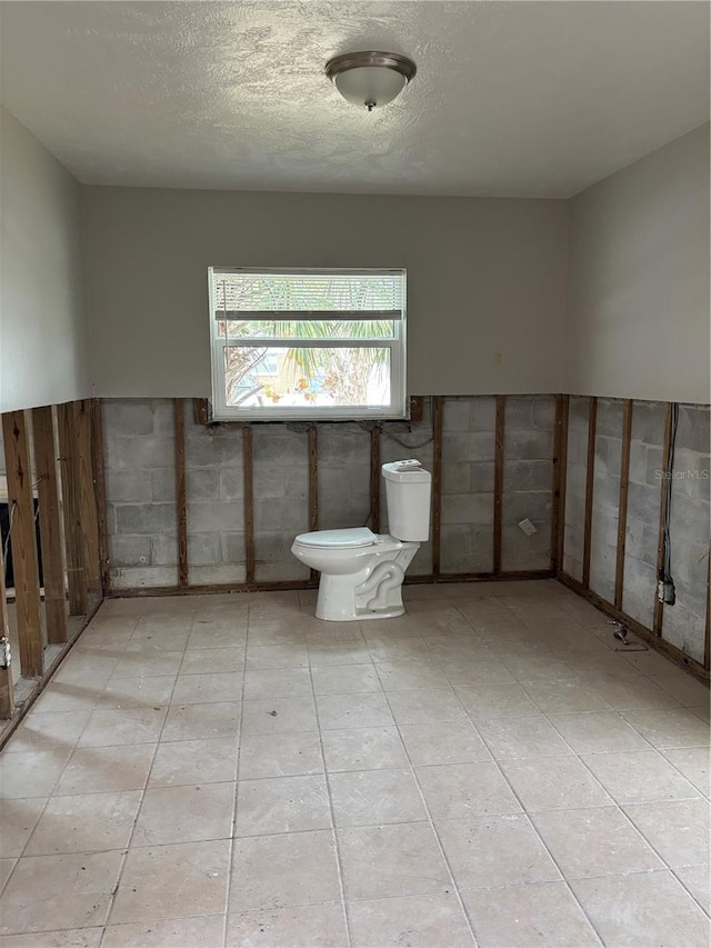 bathroom with toilet and a textured ceiling