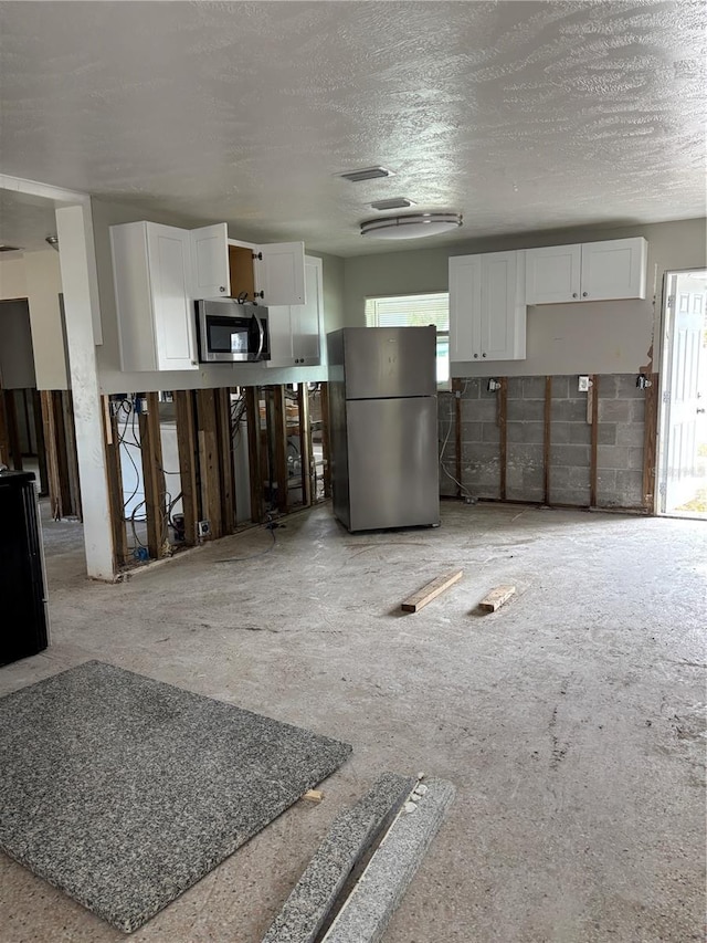 kitchen featuring white cabinets, appliances with stainless steel finishes, and a textured ceiling