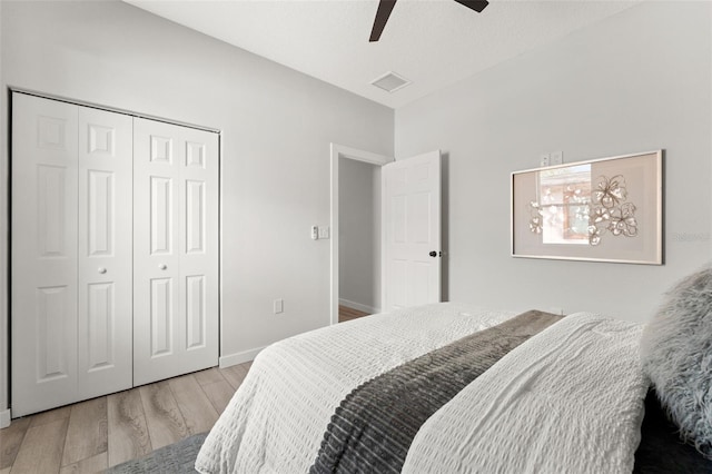 bedroom featuring ceiling fan, light hardwood / wood-style floors, and a closet