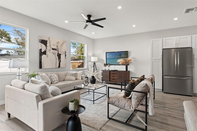 living room with light hardwood / wood-style floors and ceiling fan