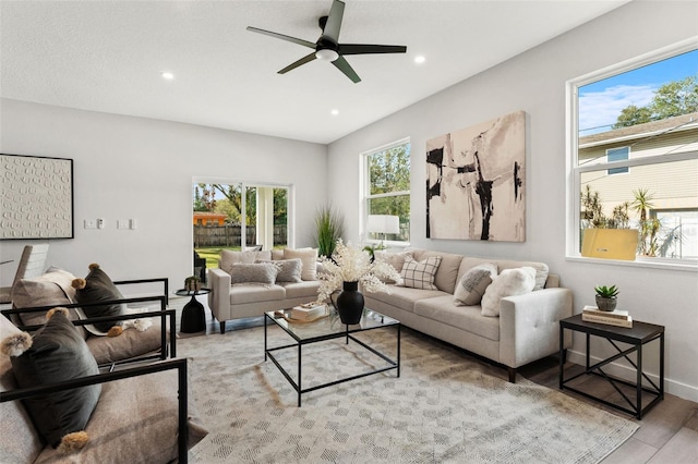 living room featuring a wealth of natural light, light hardwood / wood-style flooring, and ceiling fan