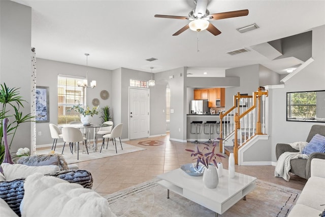 living room with ceiling fan with notable chandelier and light tile patterned flooring