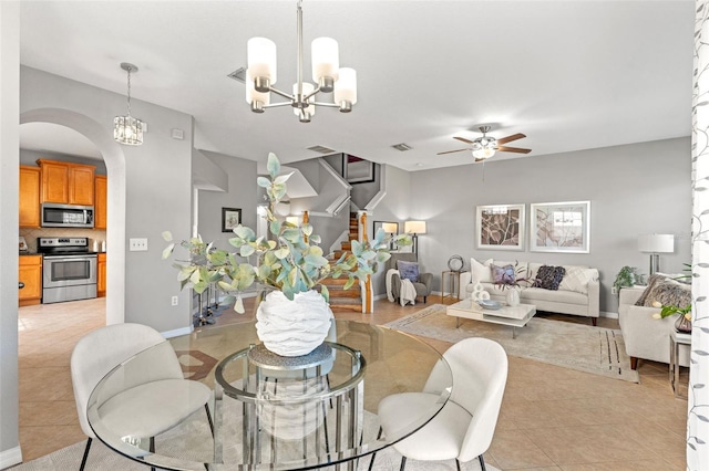 dining area with light tile patterned floors and ceiling fan with notable chandelier