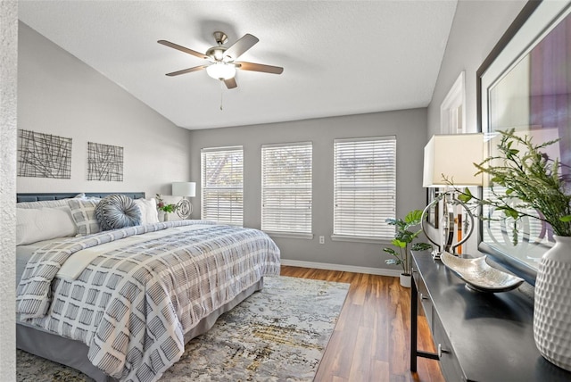 bedroom featuring ceiling fan, dark wood-type flooring, and vaulted ceiling