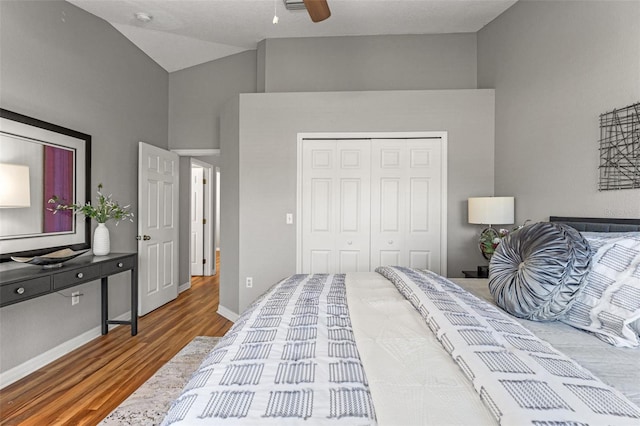 bedroom featuring lofted ceiling, ceiling fan, wood-type flooring, and a closet