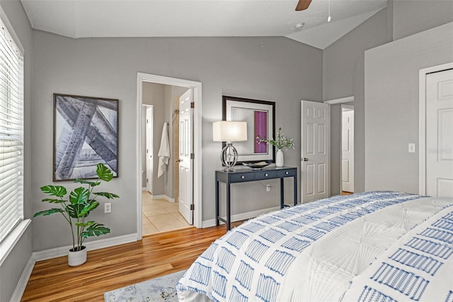 bedroom featuring ensuite bathroom, ceiling fan, light hardwood / wood-style floors, and lofted ceiling