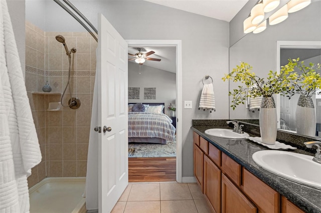 bathroom featuring tile patterned floors, vanity, vaulted ceiling, ceiling fan, and tiled shower