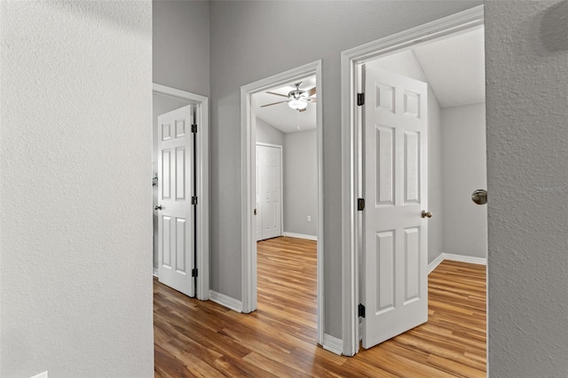 hallway featuring hardwood / wood-style flooring and vaulted ceiling