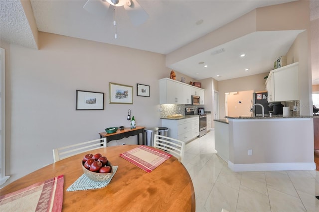 tiled dining space with ceiling fan and sink