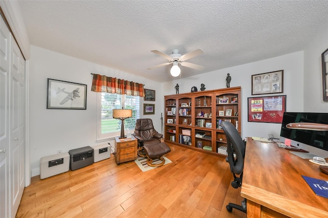 office space featuring a textured ceiling, ceiling fan, and light hardwood / wood-style flooring