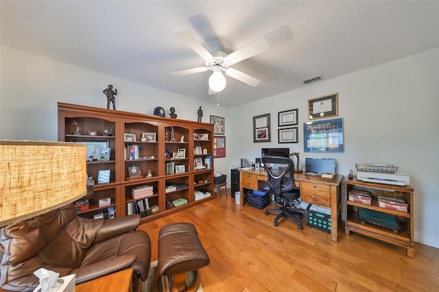 office space featuring a textured ceiling, ceiling fan, and light hardwood / wood-style flooring