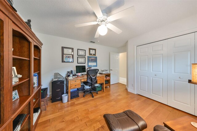 office area featuring ceiling fan, a textured ceiling, and light hardwood / wood-style flooring