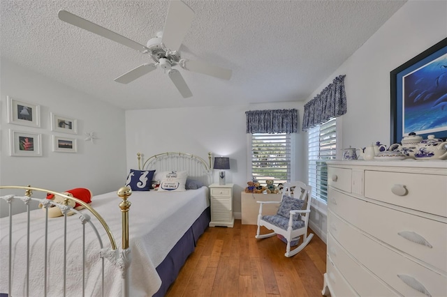 bedroom featuring ceiling fan, a textured ceiling, and hardwood / wood-style floors