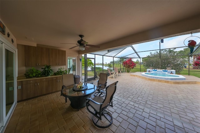 sunroom with ceiling fan and a pool with hot tub