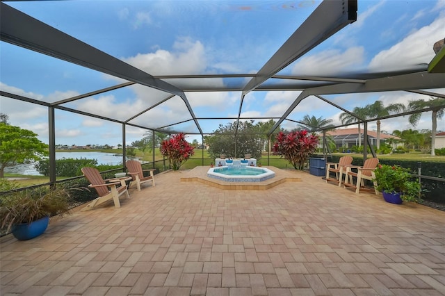 view of patio with glass enclosure, a water view, and an in ground hot tub